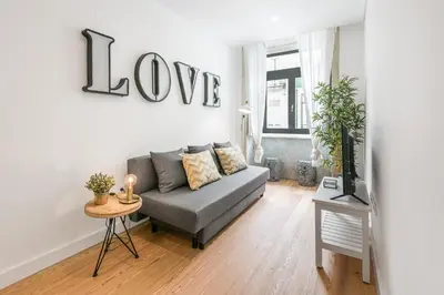 a living room with a couch and a love sign on the wall at Modern Invicta by Upperground in Porto