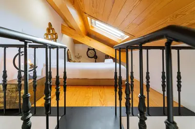 a staircase leading to a bedroom with a bed at Cozy Stay w/ AC and View in Porto
