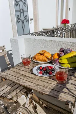 a wooden table with plates of food and fruit on it at Cozy Stay w/ AC and View in Porto