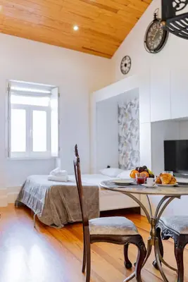 a room with a table and a bed in it at Cozy Stay w/ AC and View in Porto