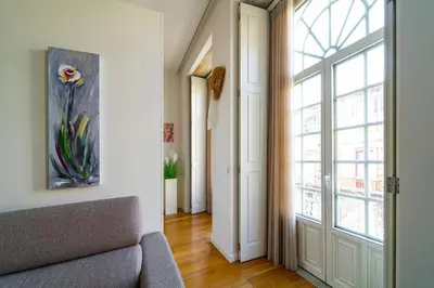 a living room with a couch and a large window at Heart of Porto by Upperground in Porto