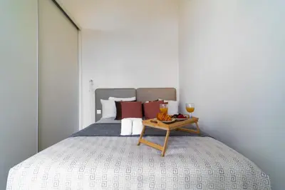 a bed with a table with a glass of wine on it at Heart of Porto by Upperground in Porto
