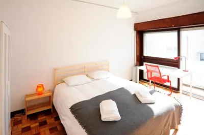 a bedroom with a bed with two towels on it at Omega White in Porto