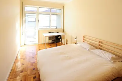 a kitchen with a wooden table and a dining room at School Santos Pousada in Porto