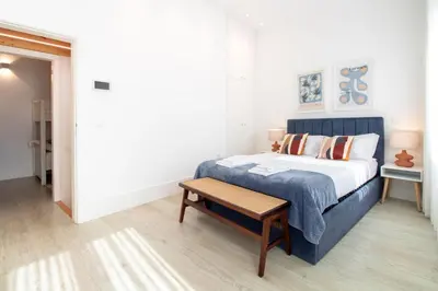 a bedroom with a king sized bed and a table at Bom Retiro's Delight by LovelyStay in Porto