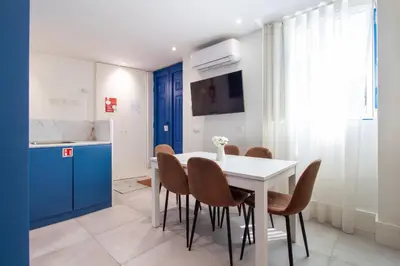 a kitchen and dining room with a white table and chairs at Bom Retiro's Delight by LovelyStay in Porto
