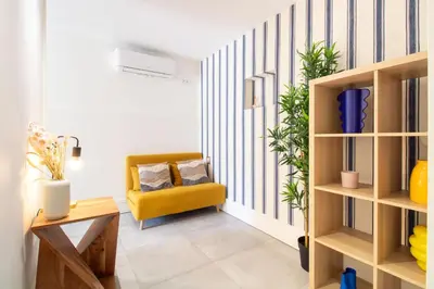 a living room with a yellow chair and a couch at Bom Retiro's Delight by LovelyStay in Porto