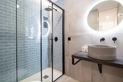 a bathroom with a sink and a glass shower at Bom Retiro's Delight by LovelyStay in Porto