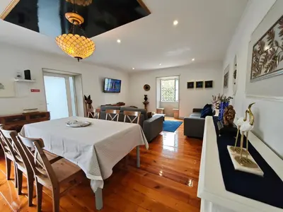 a dining room and living room with a table and chairs at Well at Home in Vila Nova de Gaia