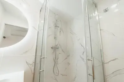 a shower with a glass door and a mirror at Cedofeita Loft by Hosty in Bicas