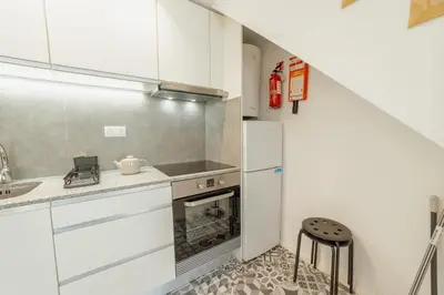 a small kitchen with a refrigerator and a sink at Cedofeita Loft by Hosty in Bicas