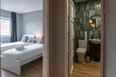 a bedroom with two beds and a sink and a mirror at 3BR Flat by Casa da Música, Central, Sleeps 6, 2D in Porto