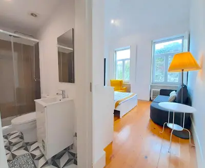 a living room with a yellow chair and a couch at Azulejos Loft, by Flat in Porto in Porto