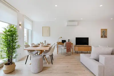 a white living room with a table and chairs at The Light Loft @ BoaVista Flats in Porto