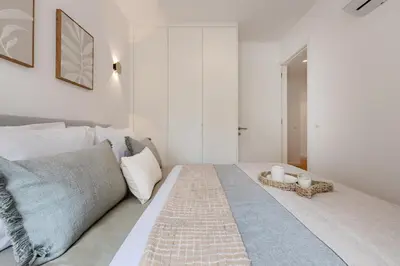 a white bedroom with a bed and a table at The Light Loft @ BoaVista Flats in Porto