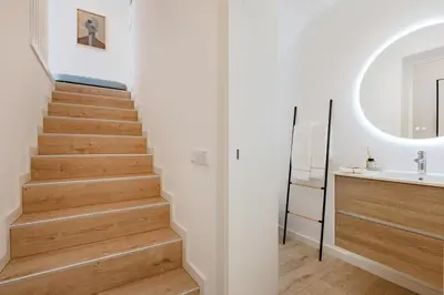 a staircase in a bathroom with a sink and a mirror at The Light Loft @ BoaVista Flats in Porto