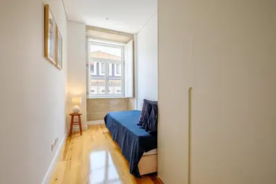 a small bedroom with a bed and a window at Porto Cedofeita Urban Charm Residence in Porto