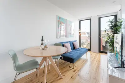a living room with a table and a blue couch at Candy Crush in Porto