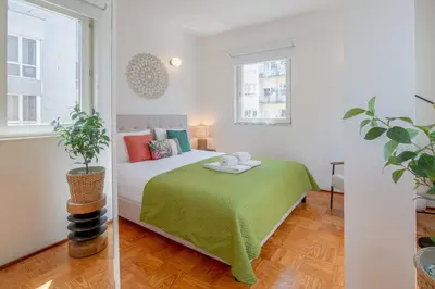 a bedroom with a bed with a green blanket at Ps70 II in Porto
