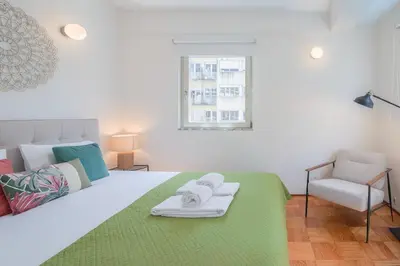 a bedroom with a large white bed with a chair at Ps70 II in Porto