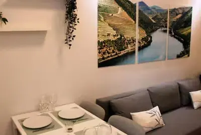 a living room with a couch and a table with glasses at Alegria Street Flat in Porto