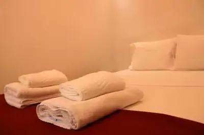 three folded towels sitting on top of a bed at Alegria Street Flat in Porto