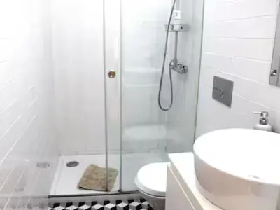a bathroom with a shower and a toilet and a sink at Alegria Street Flat in Porto