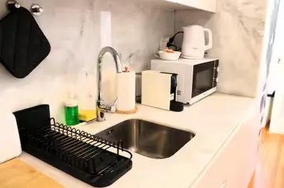 a kitchen counter with a sink and a microwave at Alegria Street Flat in Porto