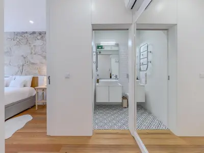 a bedroom with a bed and a bathroom at Almada Comfy in Porto