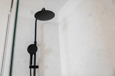 two black shower heads hanging on a wall at GuestReady – Steps from Estádio do Dragão in Porto