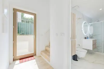 a white bedroom with a bed with two towels on it at The Sunny Duplex @ BoaVista Flats in Porto