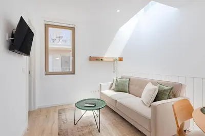 a white living room with a couch and a table at The Sunny Duplex @ BoaVista Flats in Porto