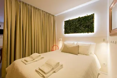 a bedroom with a bed with a plant on the wall at Luiz I Optimum Lofts 00 in Porto