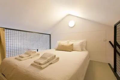 a bedroom with a white bed with towels on it at Luiz I Optimum Lofts 01 in Porto