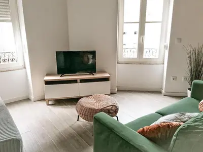 a living room with a flat screen tv on a cabinet at Mezzanine encantador no Porto in Porto