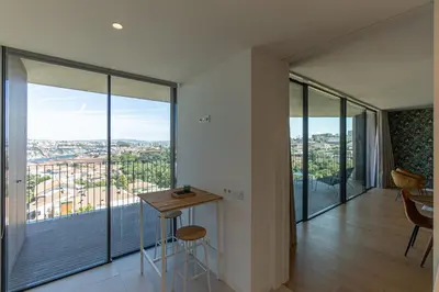 a room with a table and chairs and a large window at GuestReady - Urban luxury with Douro view in Vila Nova de Gaia