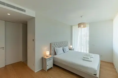 a bedroom with a white bed and a window at GuestReady - Urban luxury with Douro view in Vila Nova de Gaia