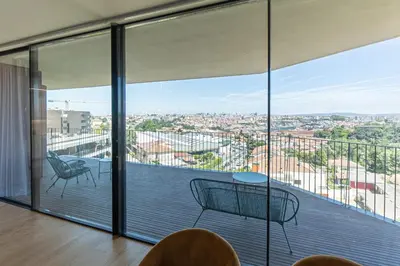 a room with a balcony with a view of a city at GuestReady - Urban luxury with Douro view in Vila Nova de Gaia