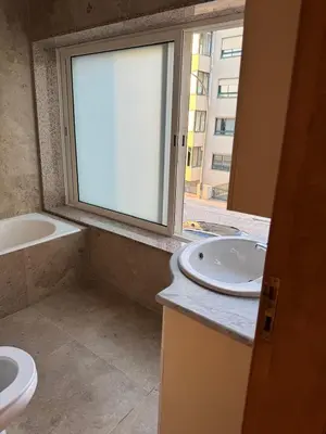 a bathroom with a toilet and a sink and a window at Hostel Antas Porto in Porto