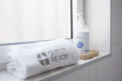 a towel and a bottle of just ready on a bathroom counter at GuestReady - Relaxing Getaway Near Porto in Vila Nova de Gaia