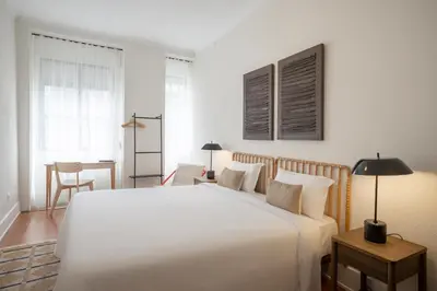 a bedroom with a large white bed and a table at Casa Verde by Olala Homes in Porto