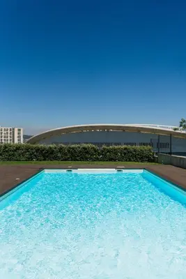 a large blue swimming pool in front of a building at Studio w/ Balcony, Pool & Gym | Antas by Host Wise in Porto