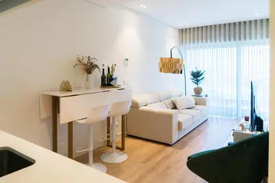 a white living room with a couch and a table at Studio w/ Balcony, Pool & Gym | Antas by Host Wise in Porto