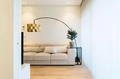 a living room with a white couch and a potted plant at Studio w/ Balcony, Pool & Gym | Antas by Host Wise in Porto