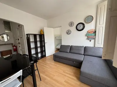 a living room with a couch and clocks on the wall at Oporto Good Vibrations -Downtown in Porto