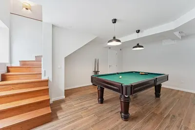 a pool table in the middle of a room with stairs at GuestReady - Fantastic family home in Salgueiros in Porto