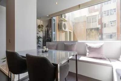 a dining room with a table and chairs and a window at Spacious 2BR en suite, downtown Porto in Porto