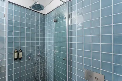 a blue tiled bathroom with a shower at GuestReady – A welcoming space to unwind in Porto