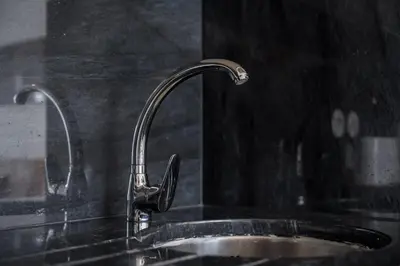 a kitchen sink with a faucet on a black counter at GuestReady – A welcoming space to unwind in Porto