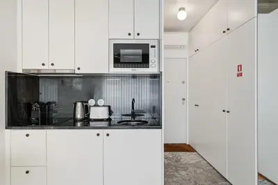 a kitchen with white cabinets and a microwave at GuestReady – A welcoming space to unwind in Porto
